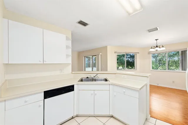 a kitchen with white cabinets and sink