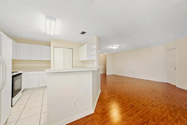 a view of a kitchen with a sink and dishwasher a refrigerator with white cabinets