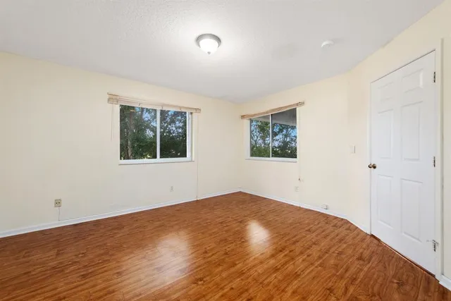 a view of empty room with wooden floor