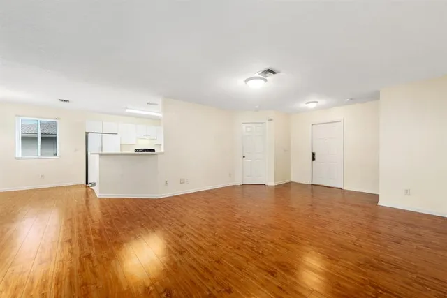 a view of empty room with wooden floor and window