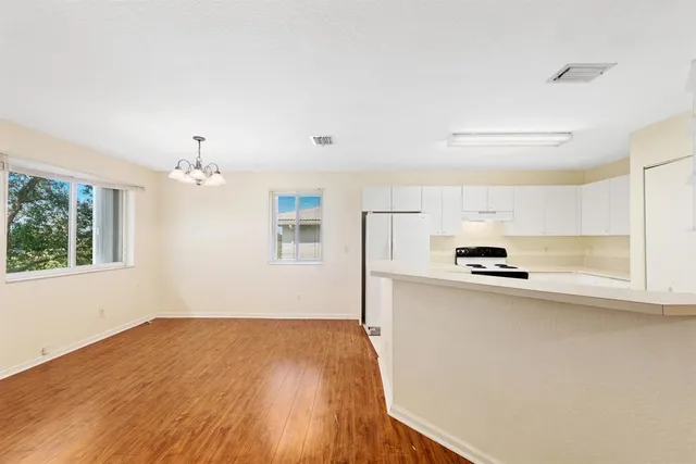 a view of a kitchen with wooden floor and a large window