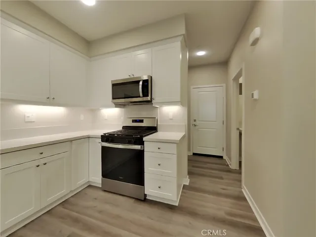 a kitchen with stainless steel appliances a stove microwave and refrigerator