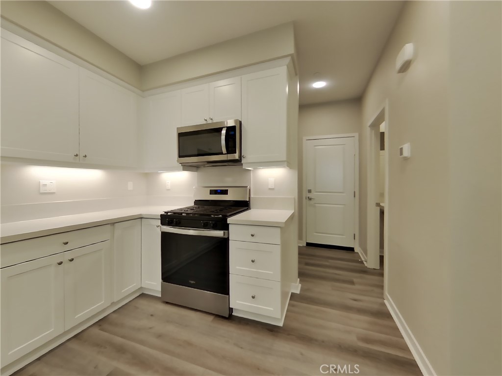 24944 Siempre Court Wildomar, CA 92595 - Photo 13 of 31 a kitchen with stainless steel appliances a stove microwave and refrigerator