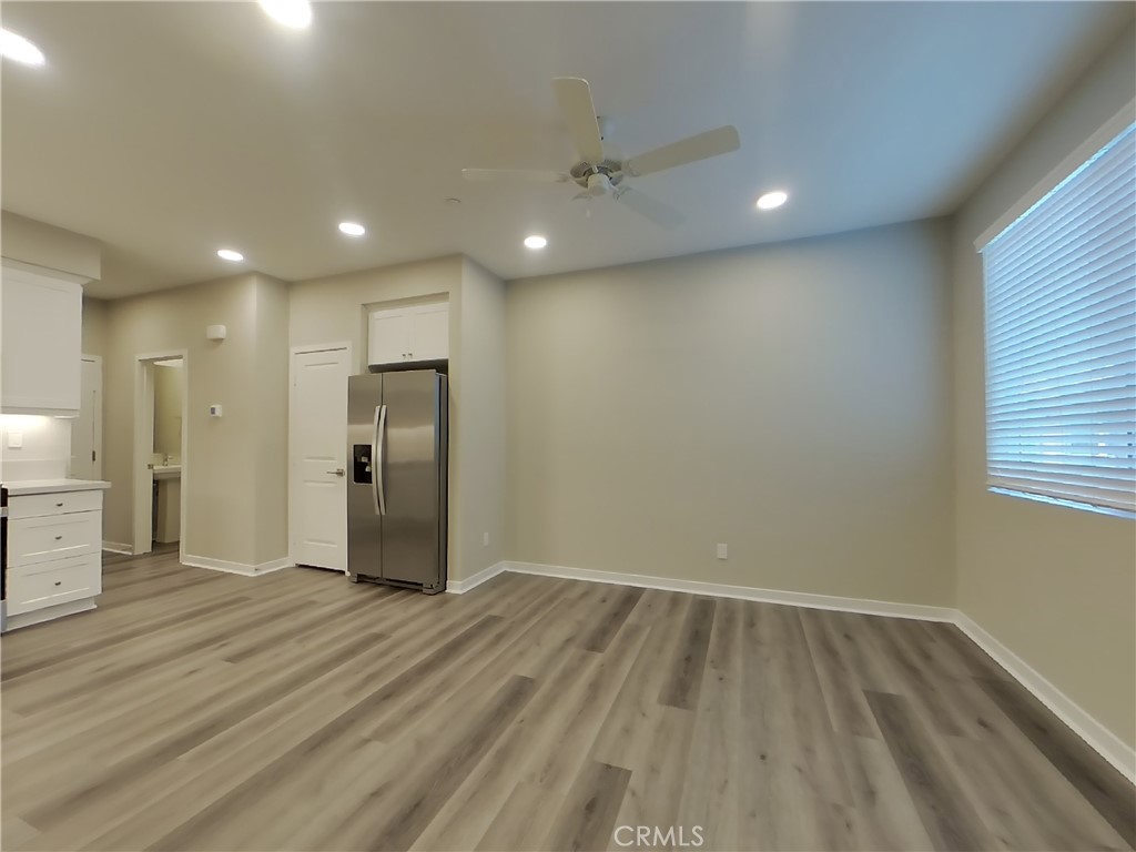 24944 Siempre Court Wildomar, CA 92595 - Photo 3 of 31 an empty room with wooden floor and windows