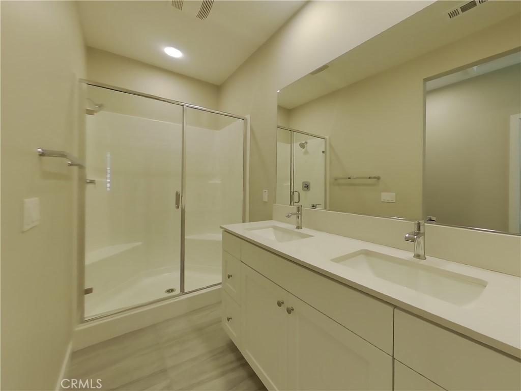 24944 Siempre Court Wildomar, CA 92595 - Photo 10 of 31 a bathroom with a shower sink and mirror