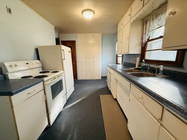 a kitchen with granite countertop a sink a stove and washer
