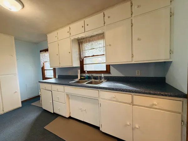a kitchen with granite countertop white cabinets and sink