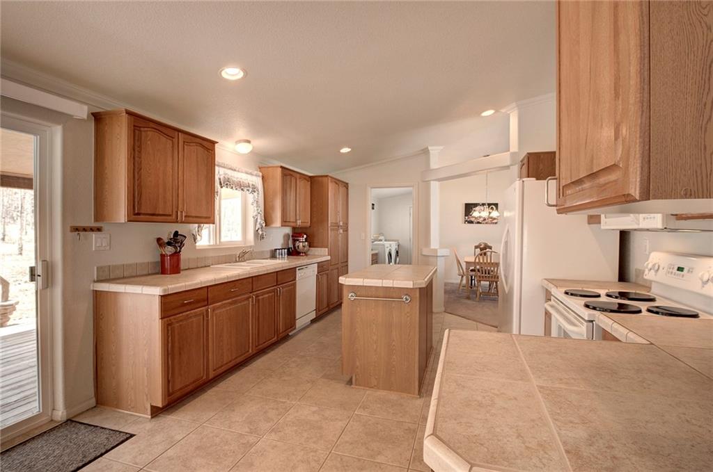 6186 Ranch Road Hartsel, CO 80449 - Photo 11 of 30 a kitchen with stainless steel appliances kitchen island granite countertop a sink and cabinets