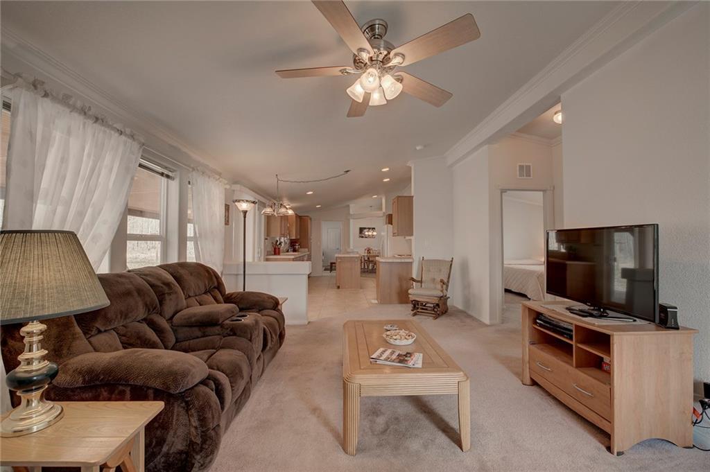 6186 Ranch Road Hartsel, CO 80449 - Photo 14 of 30 a living room with furniture a flat screen tv and kitchen view