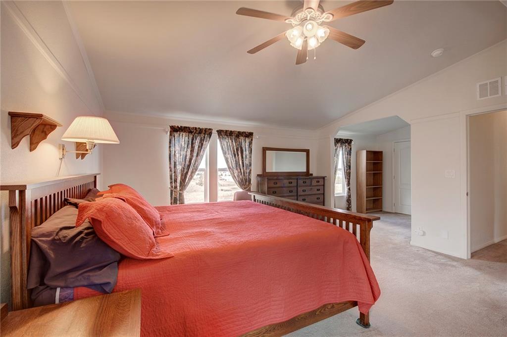6186 Ranch Road Hartsel, CO 80449 - Photo 19 of 30 a bed room with a bed and a chandelier