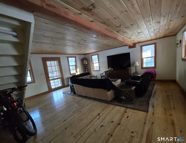 a living room with furniture wooden floor and a flat screen tv