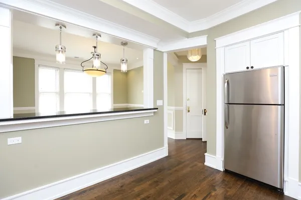 a view of a kitchen with a refrigerator and wooden floor