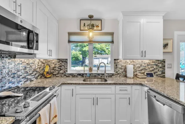 a kitchen with stainless steel appliances granite countertop a sink and a stove