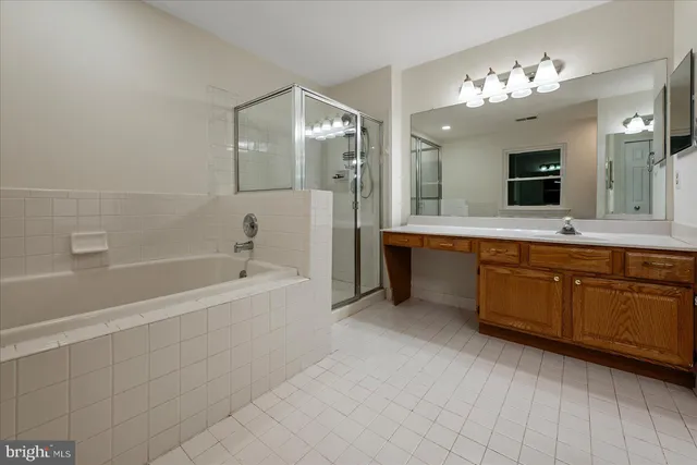 a spacious bathroom with a tub sink shower and mirror