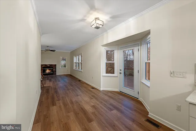 a view of a livingroom with wooden floor and a ceiling fan
