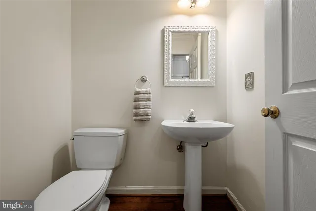 a bathroom with a toilet a sink and mirror