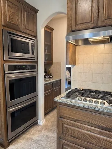 a kitchen with granite countertop cabinets stove and oven