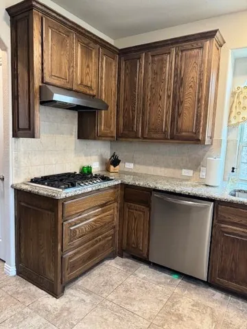 a kitchen with granite countertop a sink and a stove