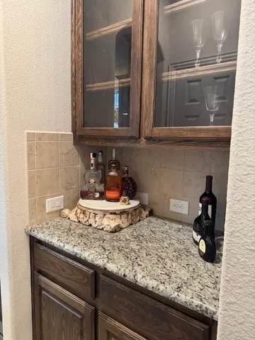 a kitchen with a granite countertop sink and cabinets