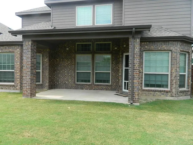 a view of patio with couple of chairs and a potted plant