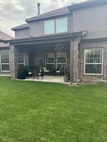 front view of a brick house with a yard
