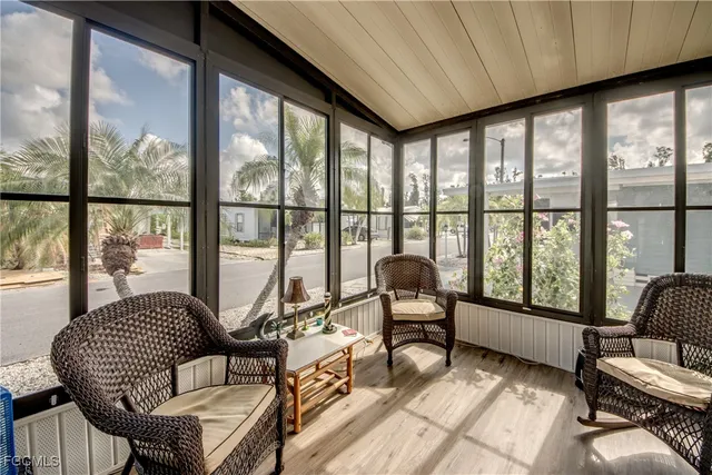 a living room with furniture and floor to ceiling windows