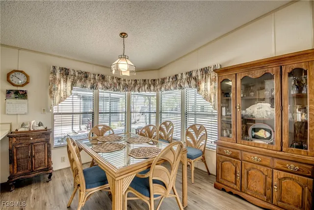 a dining room with furniture a chandelier and wooden floor