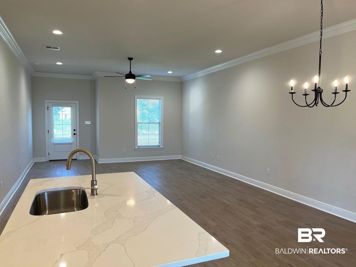 1733 Breckinridge Place Foley, AL 36535 - Photo 4 of 18 Kitchen featuring hanging light fixtures, dark hardwood / wood-style flooring, sink, and light stone countertops