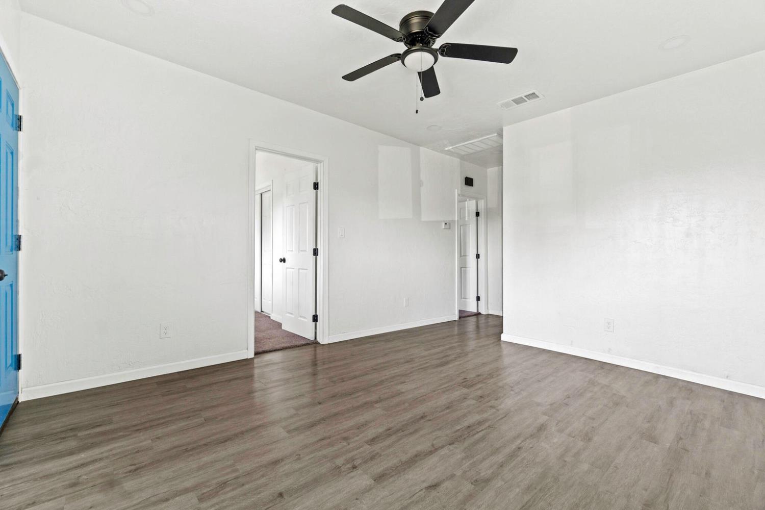 124 East 4th Street Hanford, CA 93230 - Photo 6 of 23 an empty room with wooden floor and windows