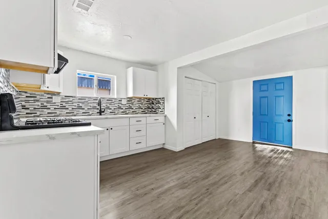 a kitchen with granite countertop white cabinets and stainless steel appliances