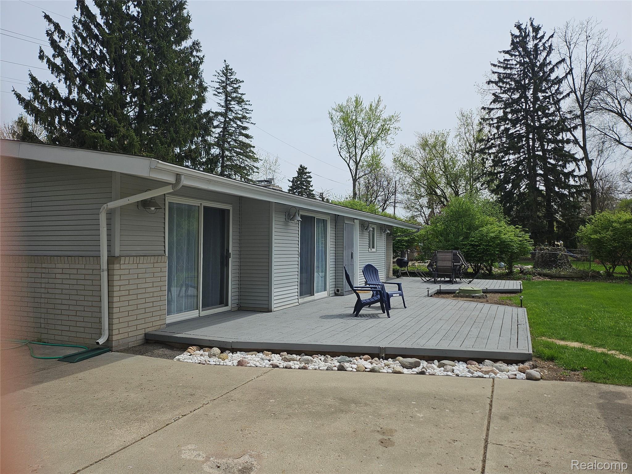 2121 South Commerce Road Walled Lake, MI 48390 - Photo 12 of 13 Back of house featuring a deck, brick siding, and a yard