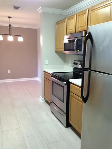a kitchen with stainless steel appliances granite countertop a sink and a refrigerator