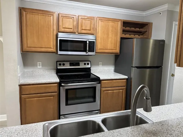 a kitchen with stainless steel appliances granite countertop a refrigerator stove and sink