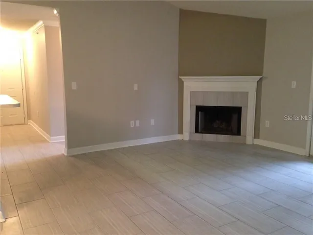 a view of an empty room with a fireplace and a window