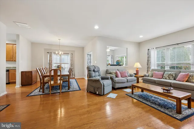 a living room with furniture wooden floor and a large window