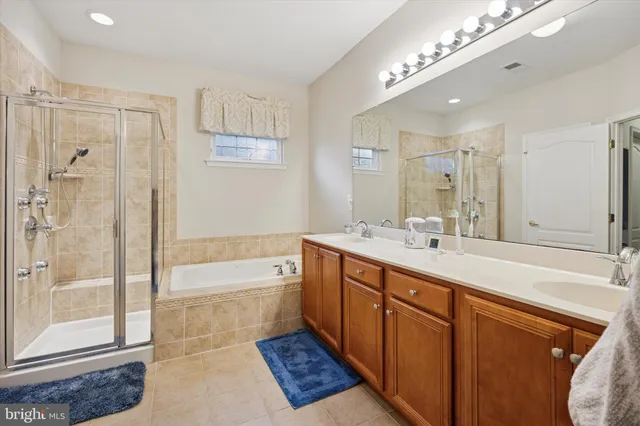 a spacious bathroom with a double vanity sink a large mirror and shower