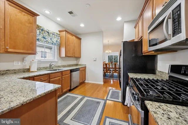 a kitchen with stainless steel appliances granite countertop a stove and a sink