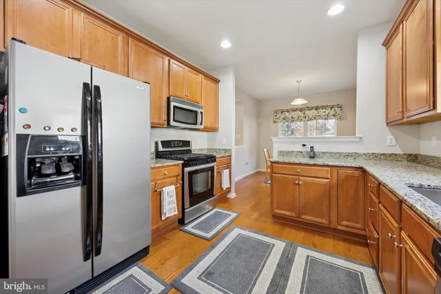 a kitchen with stainless steel appliances granite countertop a refrigerator stove and sink