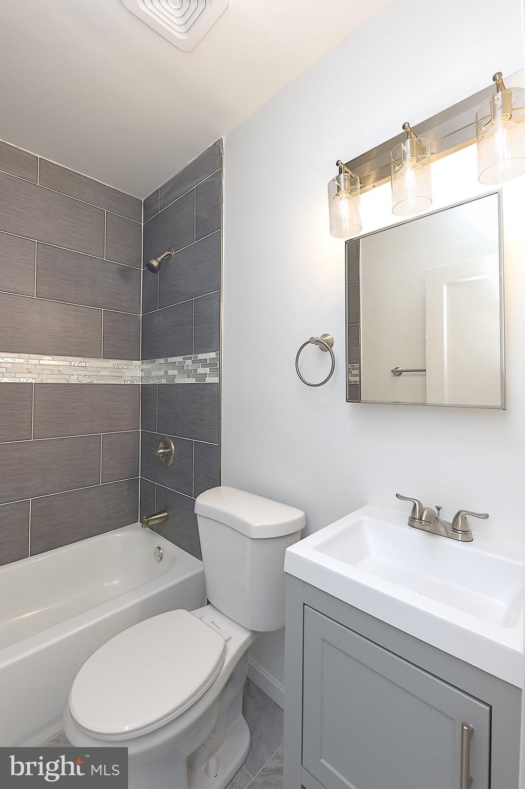 2995 Yorkway, Unit 1 Dundalk, MD 21222 - Photo 11 of 19 a white toilet sitting next to a bathroom sink and a tub