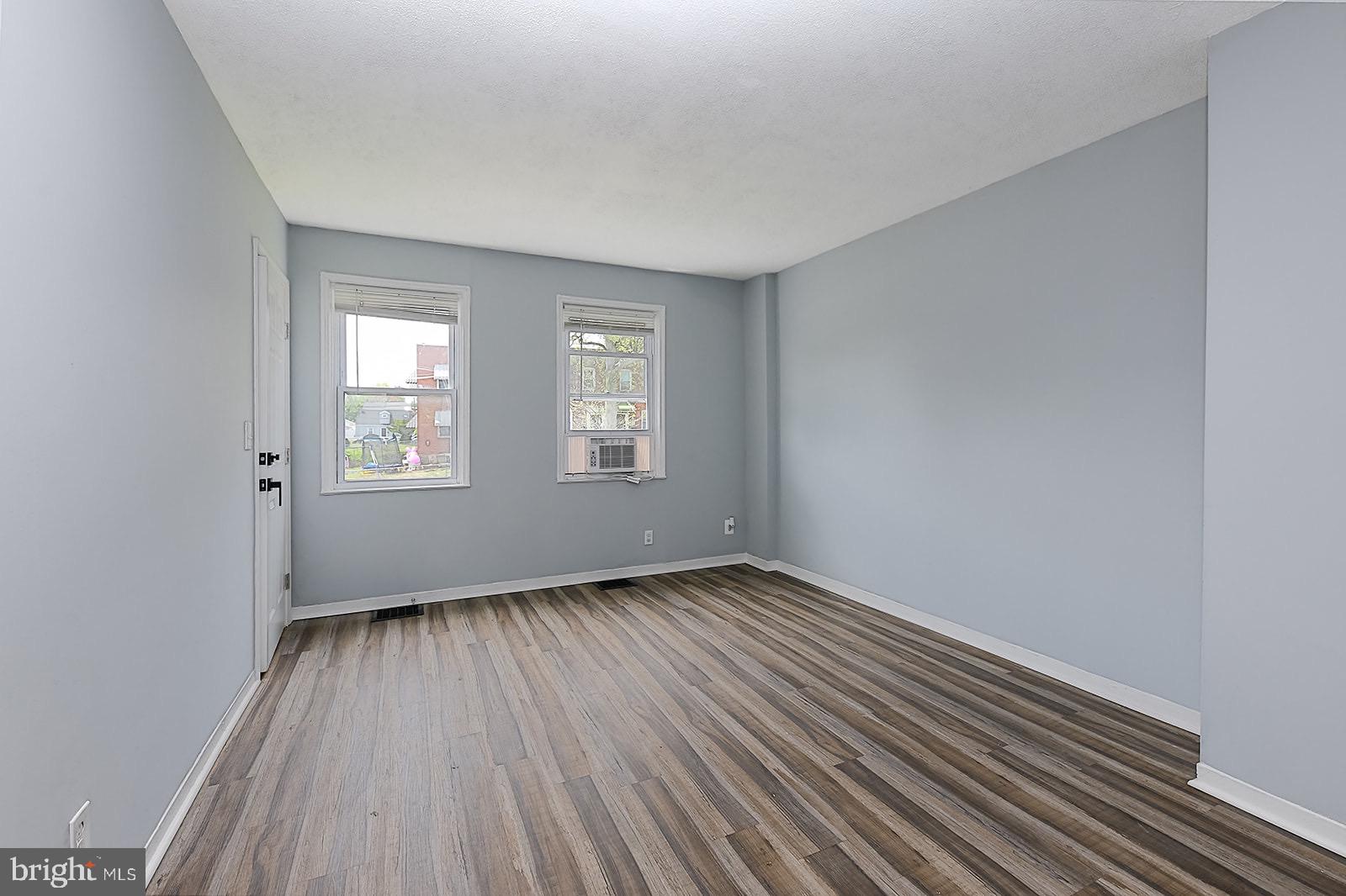 2995 Yorkway, Unit 1 Dundalk, MD 21222 - Photo 13 of 19 a view of an empty room with wooden floor and a window