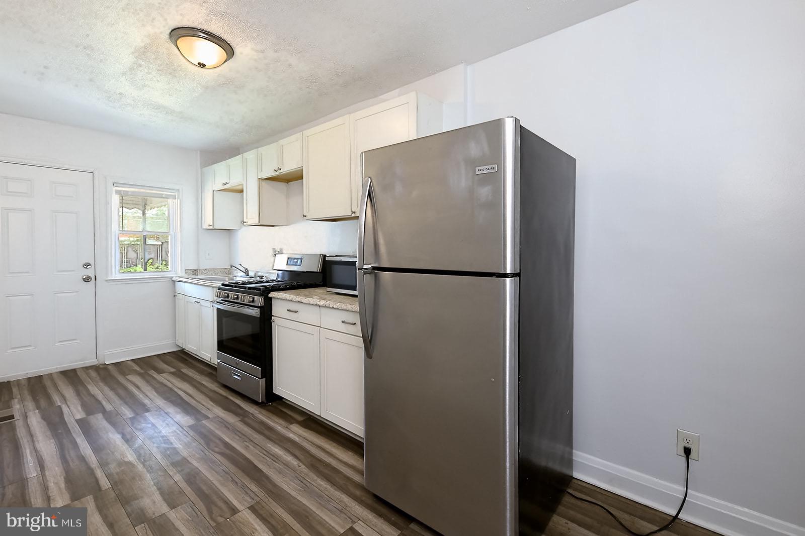 2995 Yorkway, Unit 1 Dundalk, MD 21222 - Photo 2 of 19 a kitchen with a refrigerator and a stove top oven