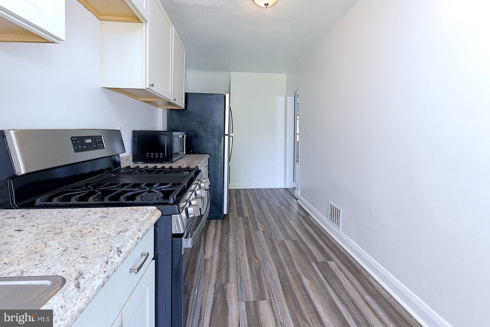 2995 Yorkway, Unit 1 Dundalk, MD 21222 - Photo 3 of 19 a kitchen with wooden floor and a stove top oven