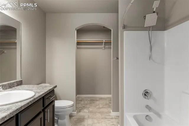 a bathroom with a granite countertop sink a toilet and shower