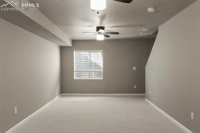 en empty room with windows and ceiling fan