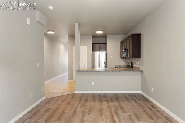 a view of kitchen and hall with wooden floor