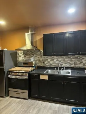 a kitchen with stainless steel appliances wooden cabinets and a stove top oven