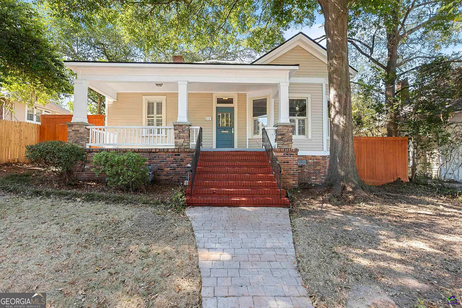 a front view of a house with a yard and potted plants