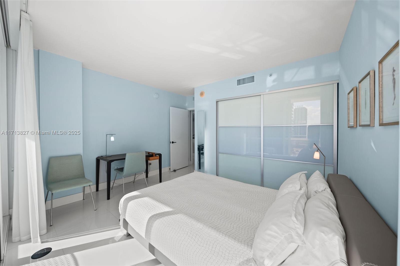 6801 Collins Avenue, Unit 1214 Miami Beach, FL 33141 - Photo 19 of 59 a bedroom with a bed and a mirror