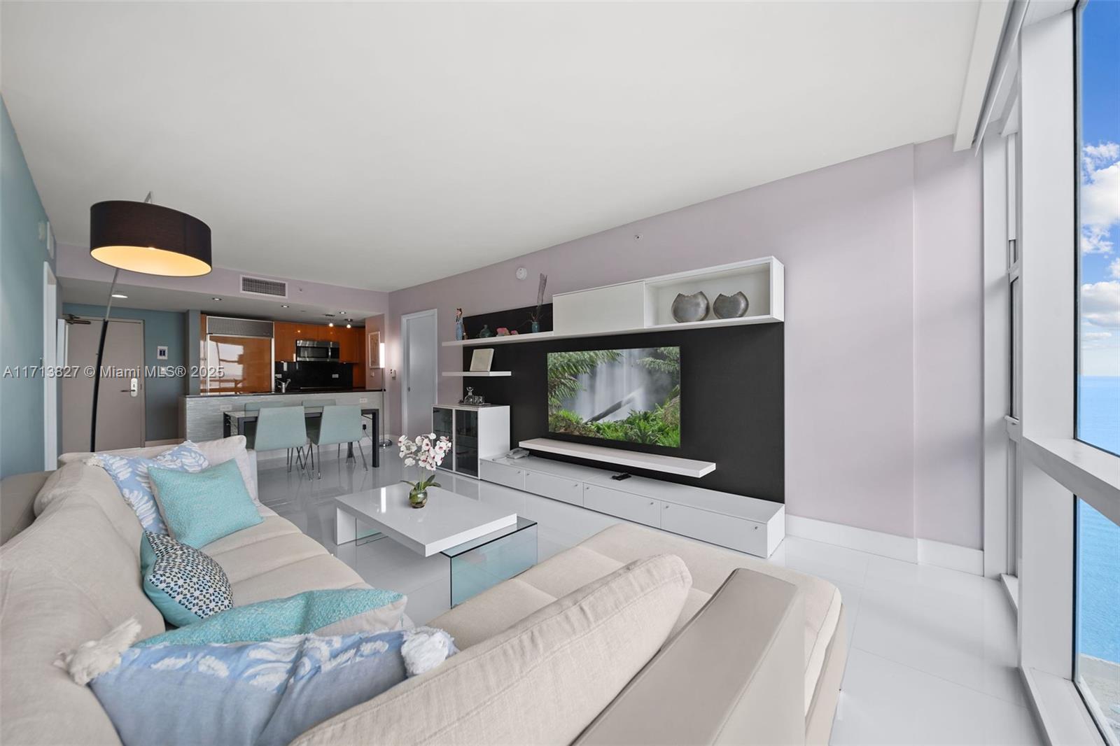 6801 Collins Avenue, Unit 1214 Miami Beach, FL 33141 - Photo 6 of 59 a living room with furniture and a flat screen tv