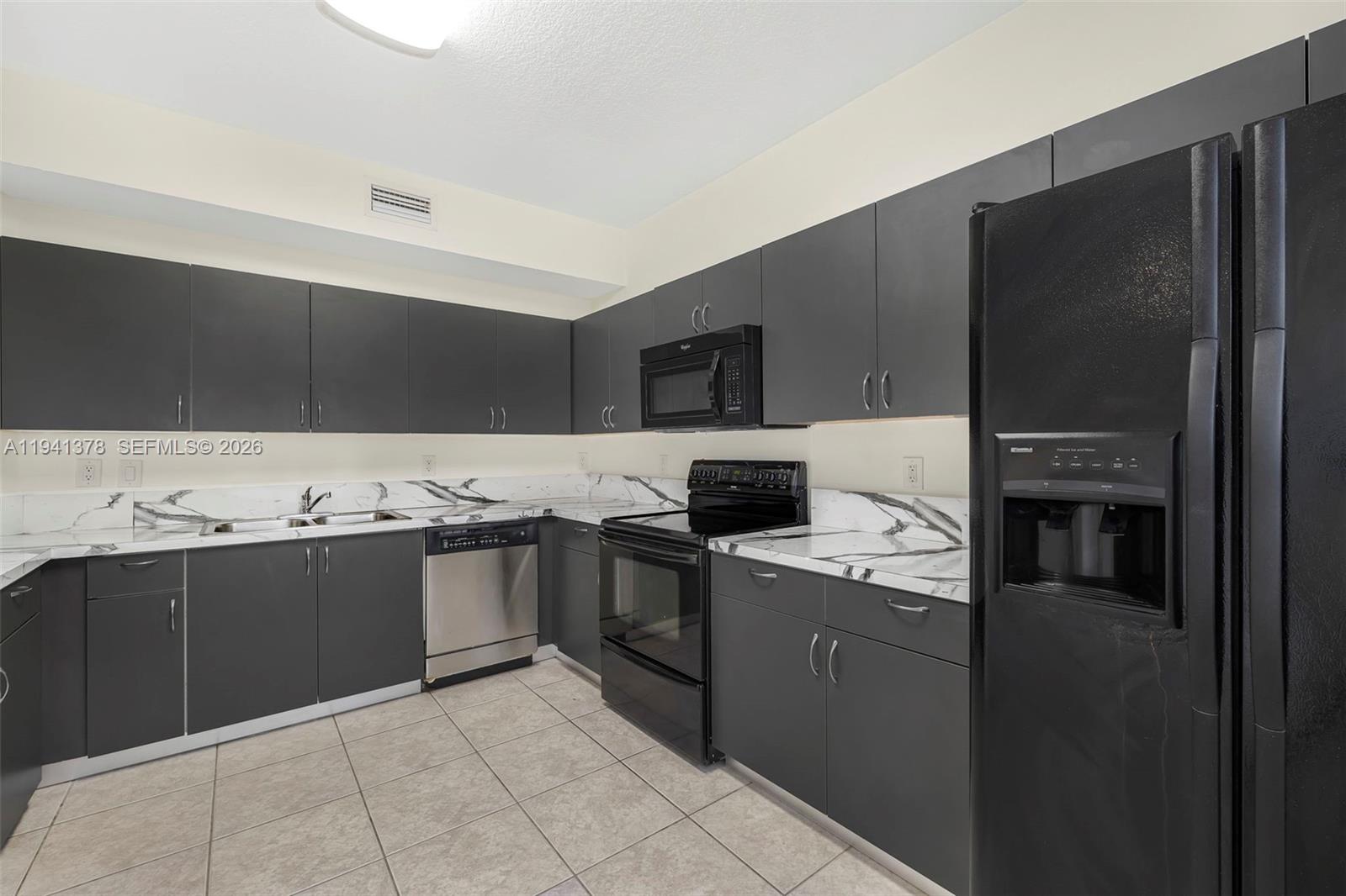 8331 Southwest 124th Avenue, Unit 10414 Miami, FL 33183 - Photo 11 of 24 a modern kitchen with stainless steel appliances granite countertop a stove and a refrigerator